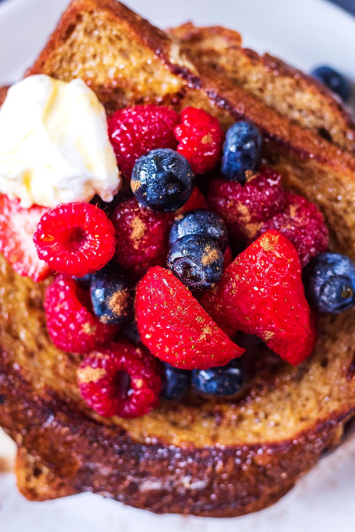 A mixture of berries on top of some French toast