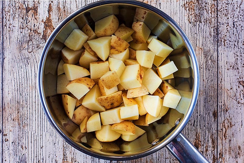 A saucepan containing cubes of potato.