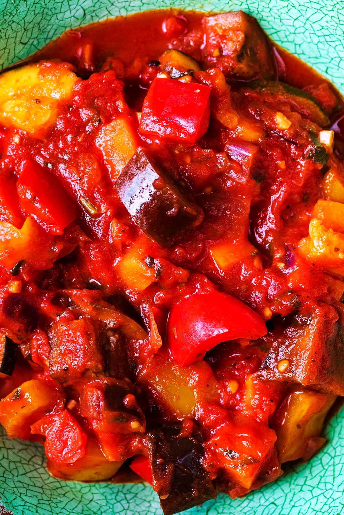 A dish of ratatouille containing peppers, eggplant, onion, zucchini, carrot and tomatoes.