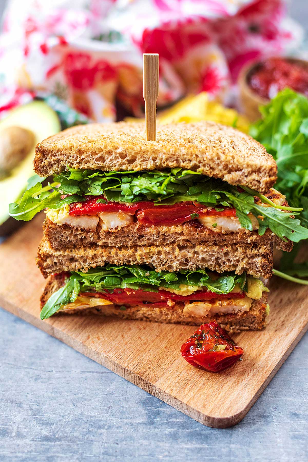 A halloumi sandwich stacked up on a wooden board.