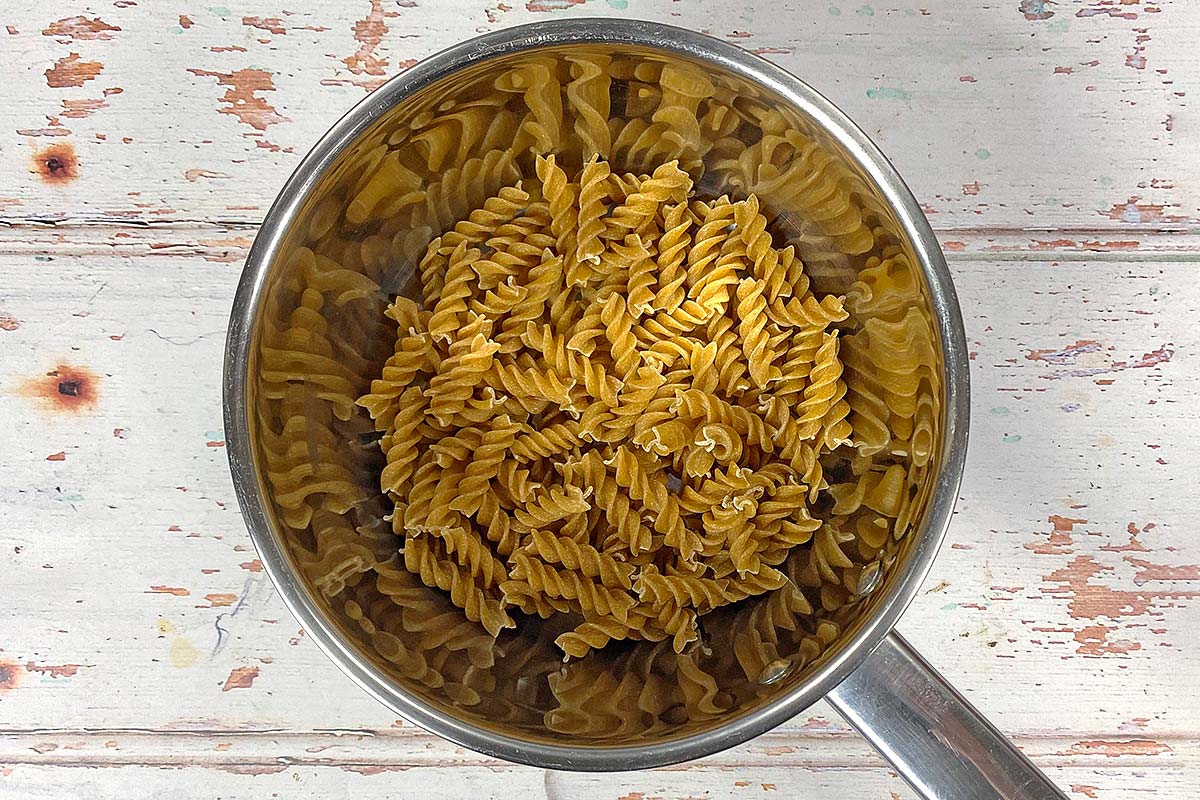 A saucepan containing uncooked fusilli pasta.