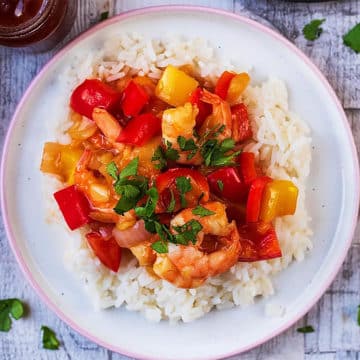 A plate of sweet and sour prawns on a bed of white rice