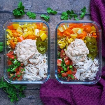 Two meal prep Mexican pasta salads on a wooden surface.