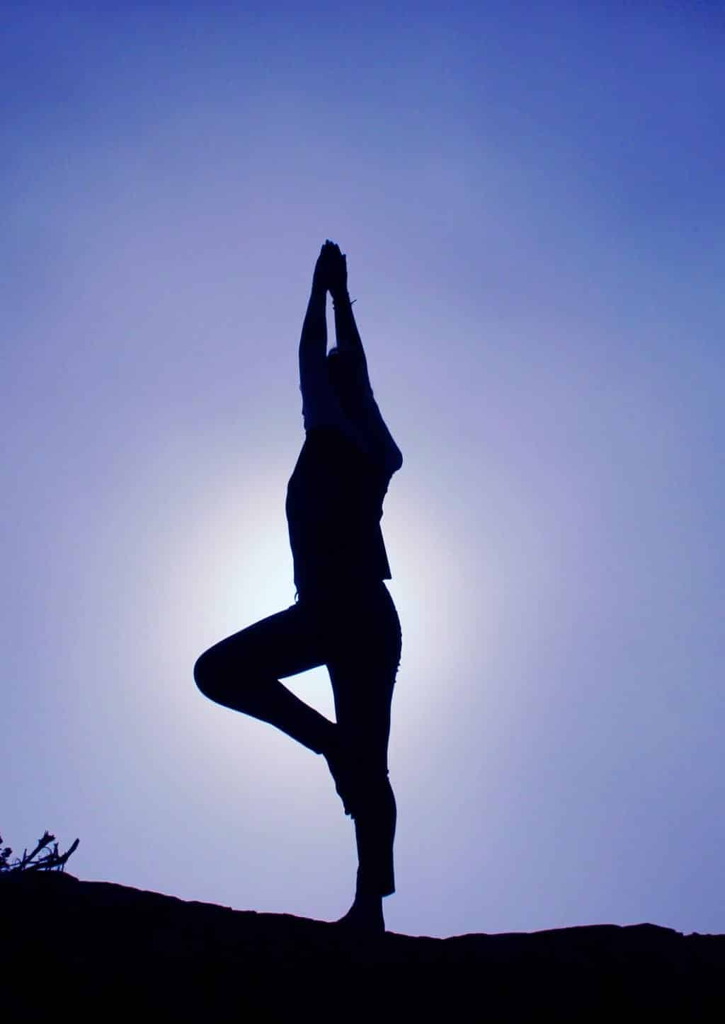 A silhouette of a person doing Yoga.