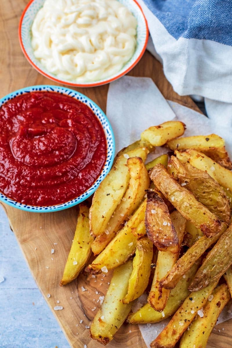 Healthy Tomato Ketchup in a dish on a serving board with chips.