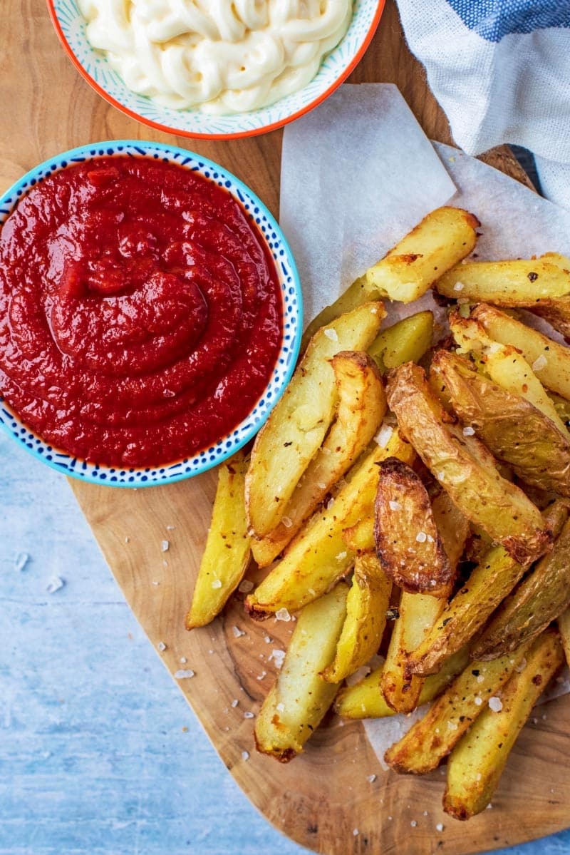 A bowl of Tomato Ketchup next to some fries and mayonnaise.