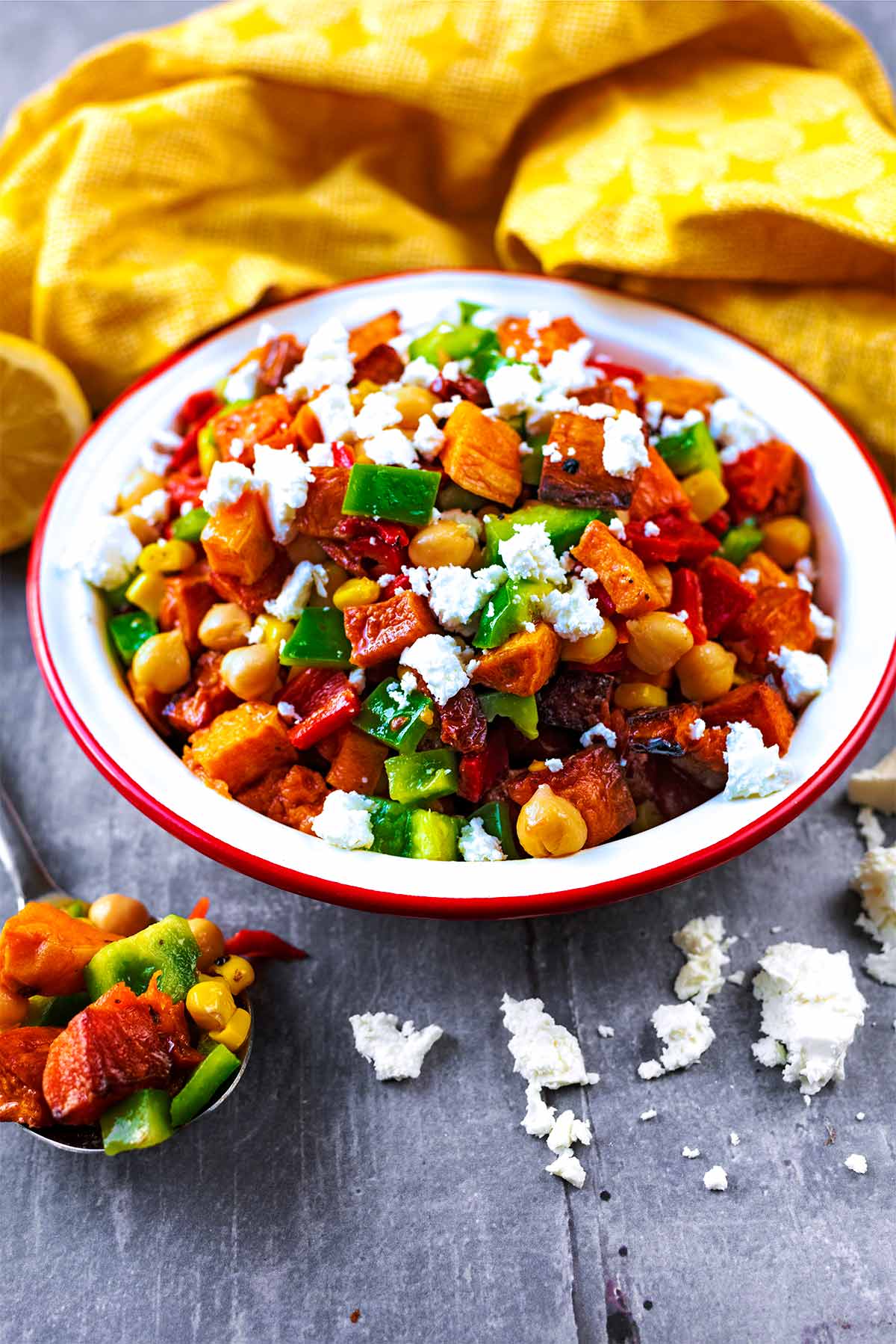Sweet potato salad in a bowl with crumbled feta scattered around it.