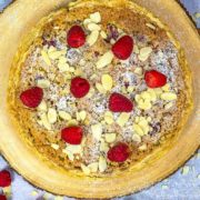 Bakewell pudding topped with icing sugar, fresh raspberries and flaked almonds.