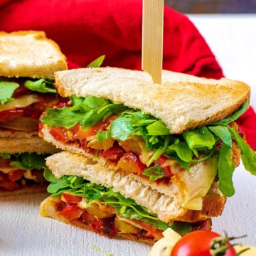 A stack of pizza sandwich with a skewer through them.
