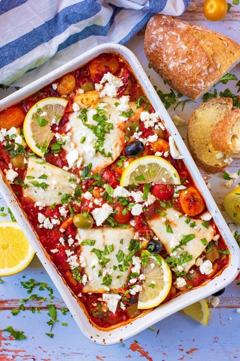 Cod fillets baked in a tomato sauce in a large baking dish.