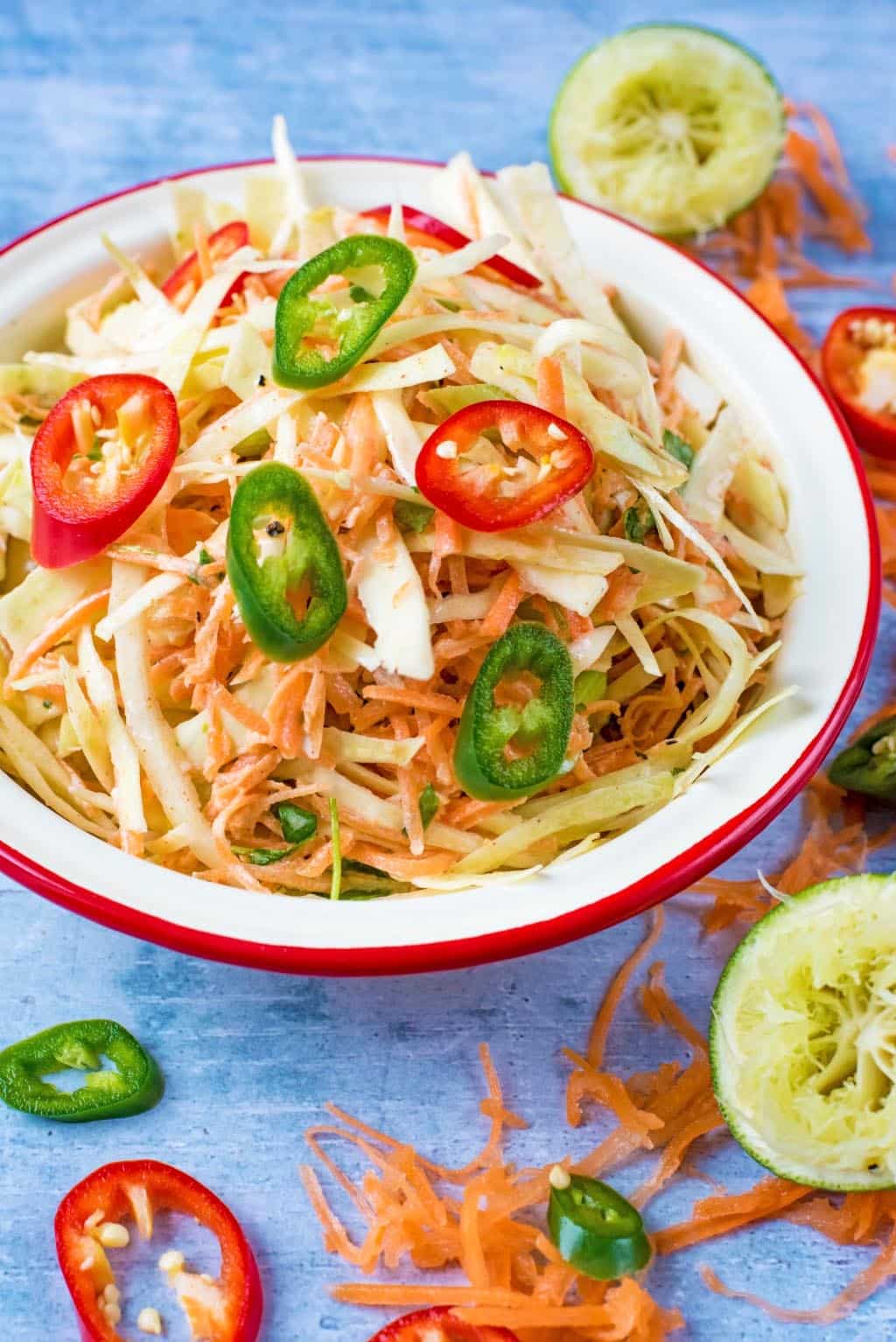 A bowl of coleslaw topped with sliced chillies.