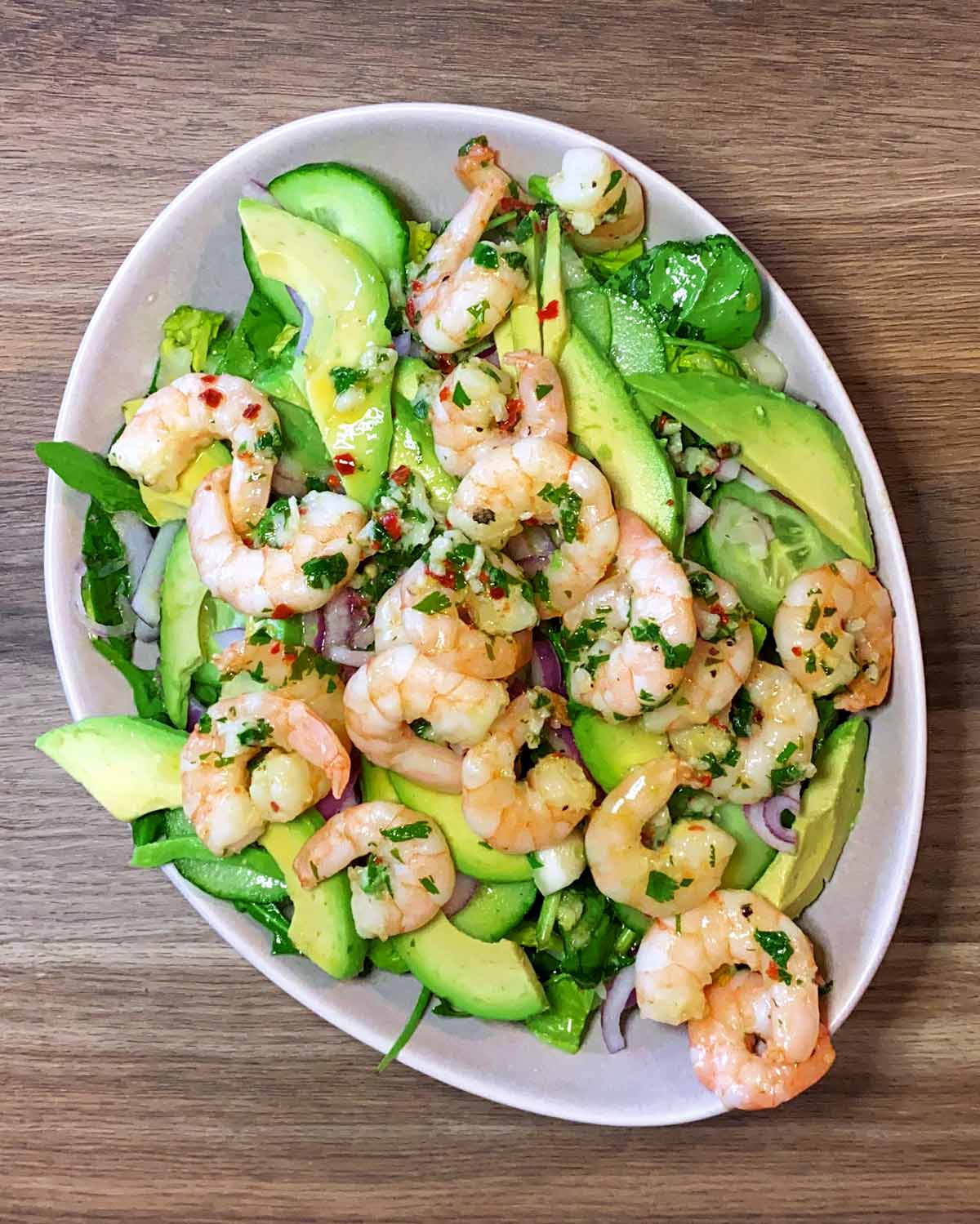 Cucumber, avocado and cooked prawns added to the bowl of lettuce.