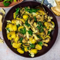 Spinach and mushroom gnocchi in a round bowl.