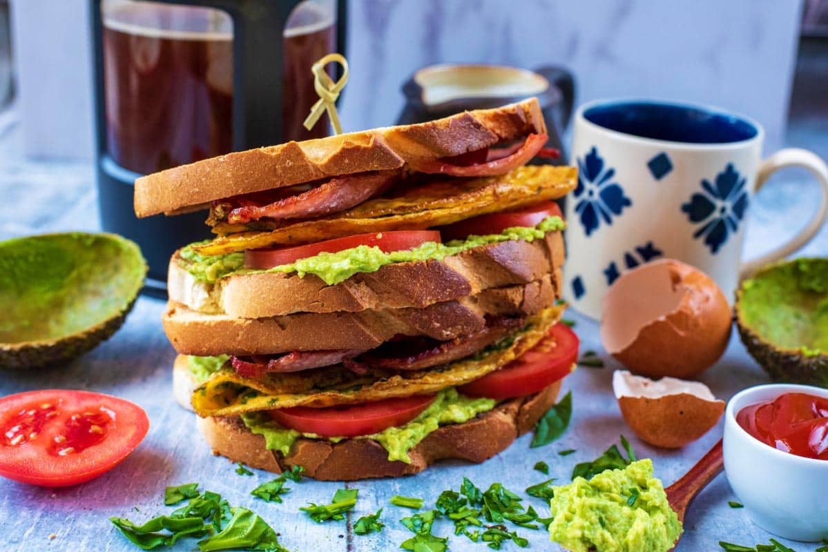 Toasted breakfast sandwich surrounded by various breakfast items