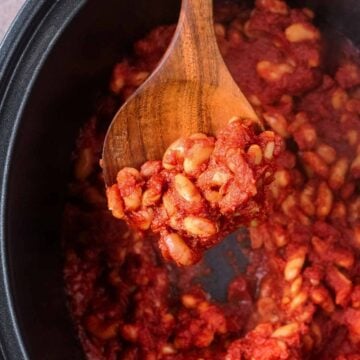 A serving spoon full of slow cooker baked beans.