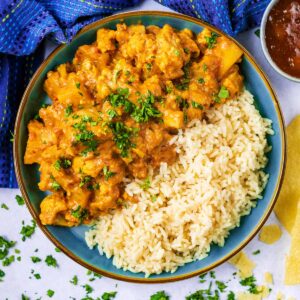 Cauliflower and potato curry on a plate with some rice.