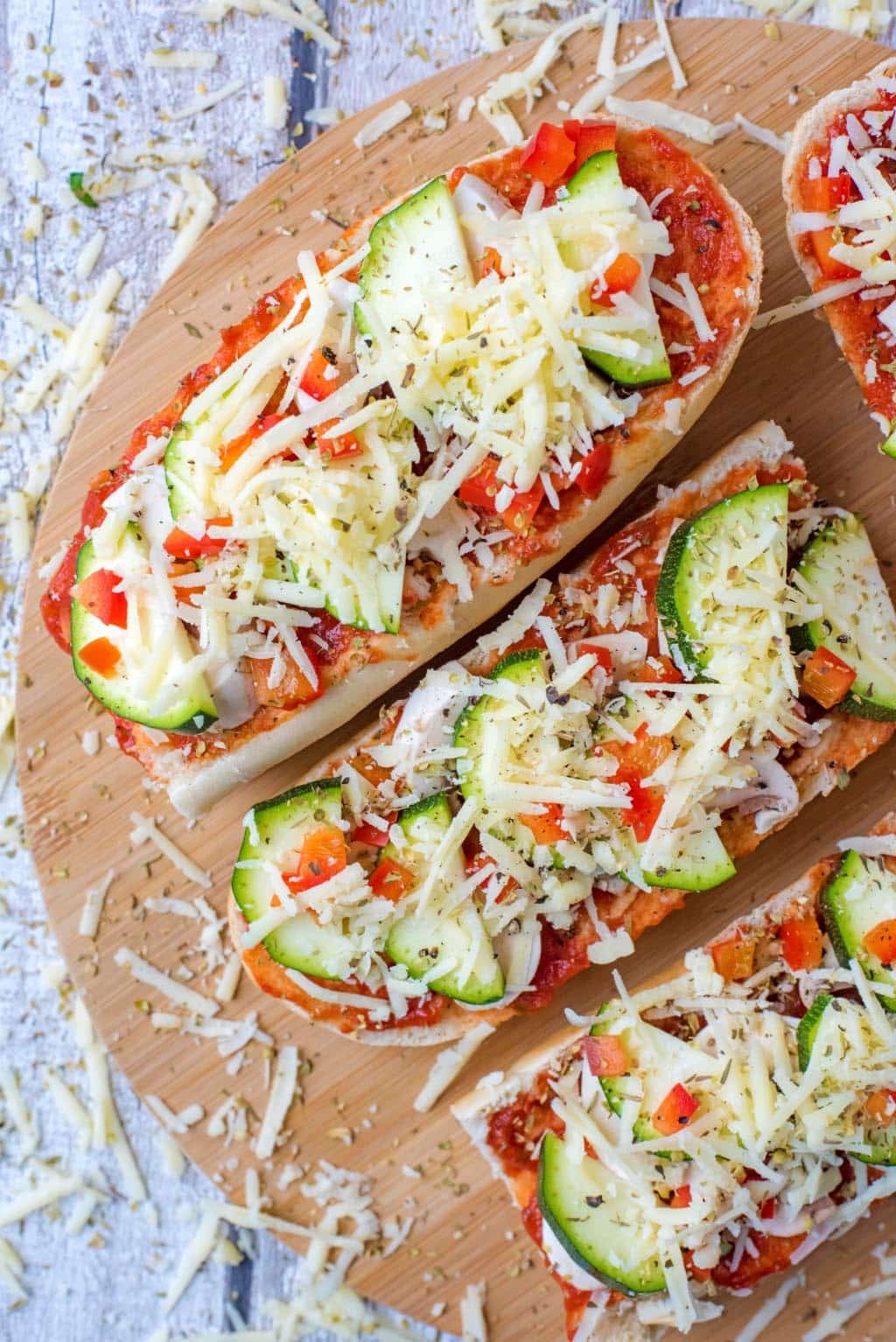 Sliced French bread topped with vegetables and cheese.