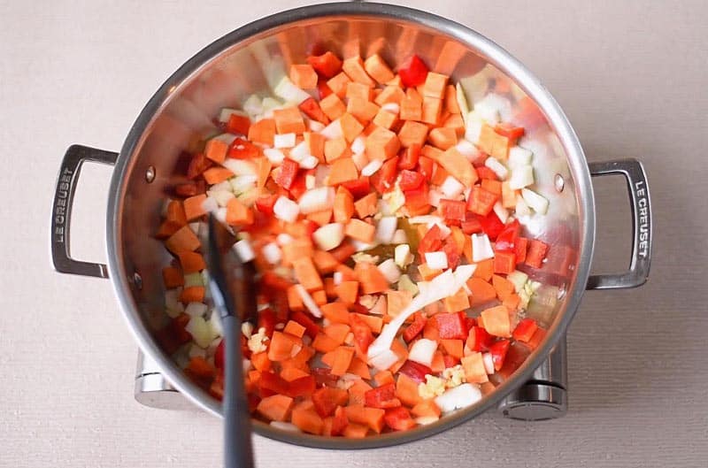 A large pan with chopped vegetables cooking in it.