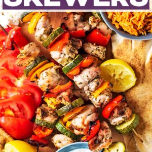 A board of Greek chicken skewers with a text title overlay.