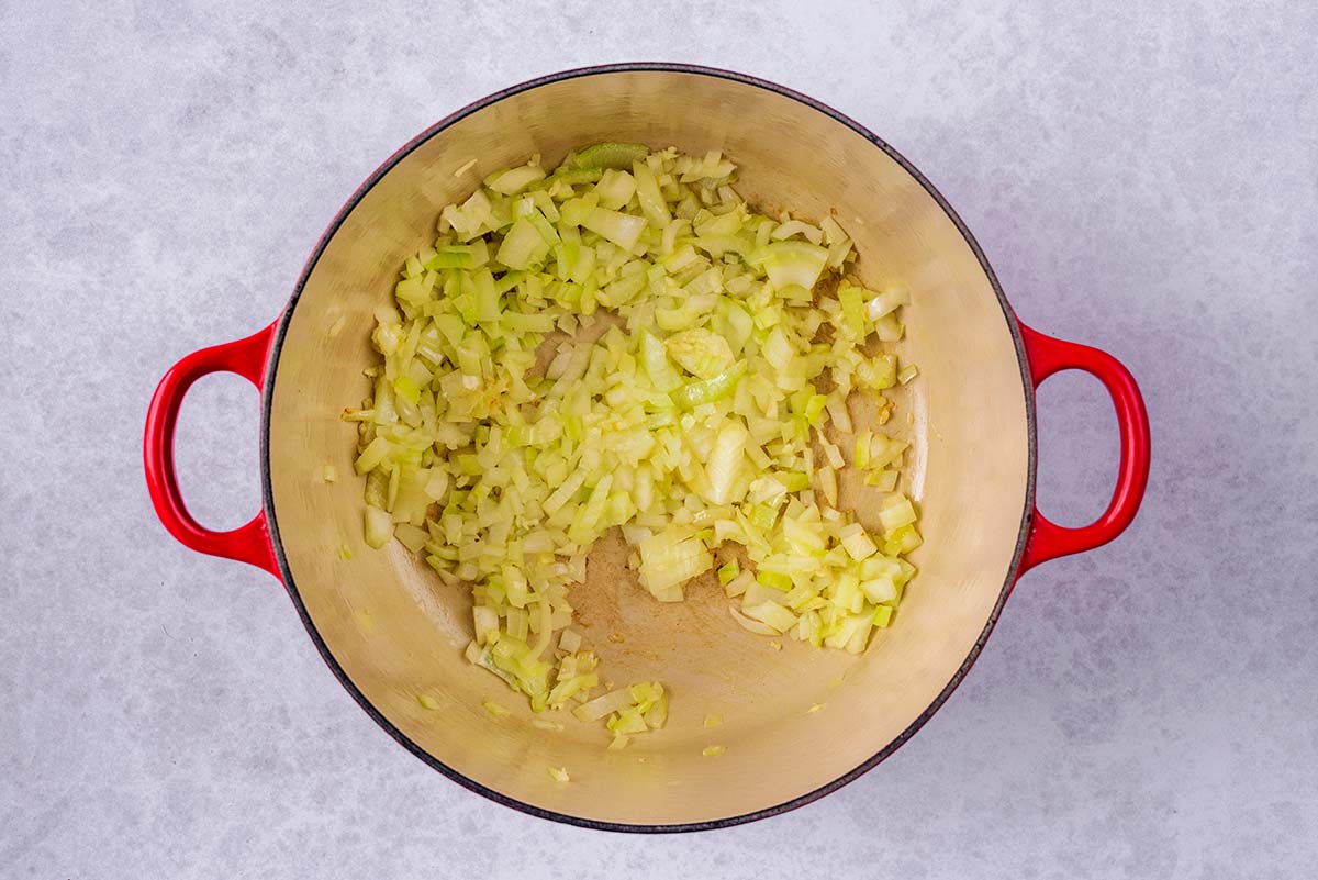 A large pan with chopped onions cooking in it.