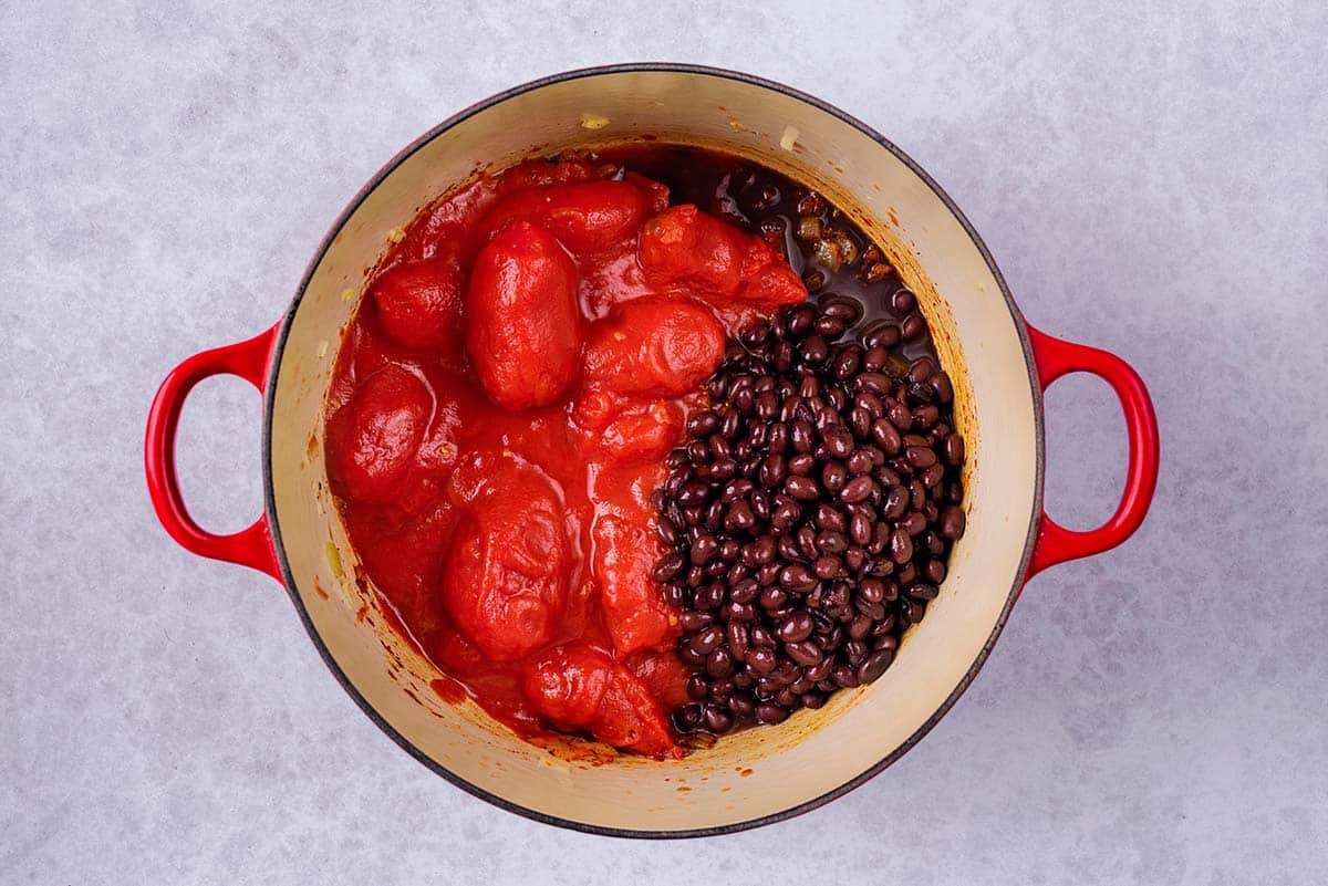 Tomatoes and black beans added to the pan.