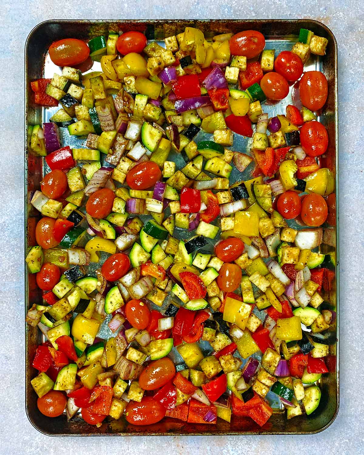 A baking tray covered in chopped vegetables.
