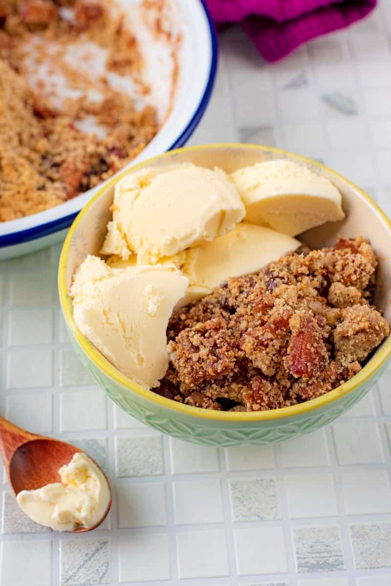 A bowl of Apple and Cherry Crumble with ice cream.