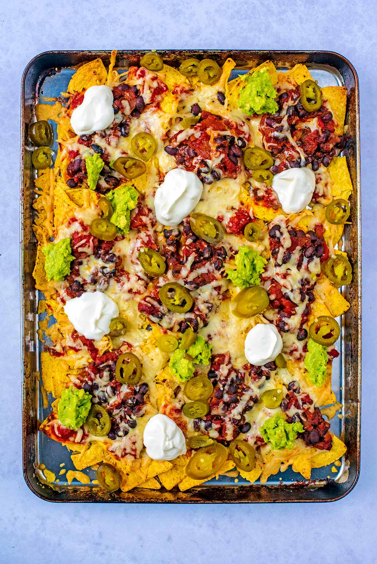 A baking tray covered in nachos.