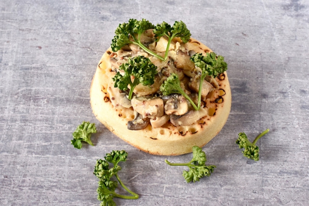 A Crumpet topped with mushrooms and parsley