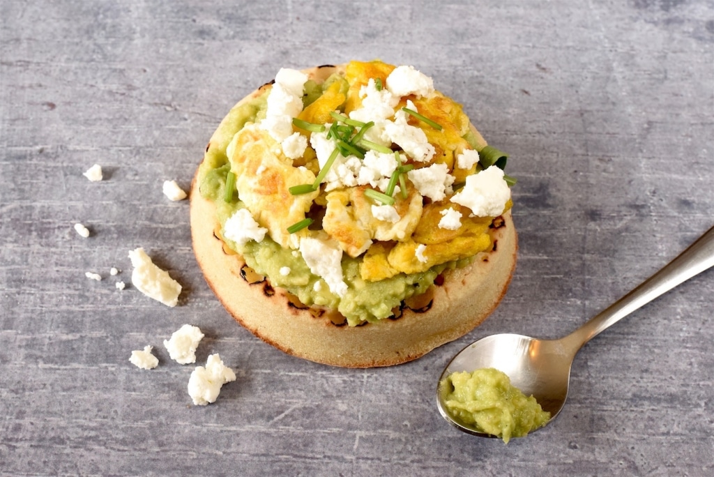 A Crumpet topped with avocado, egg and feta