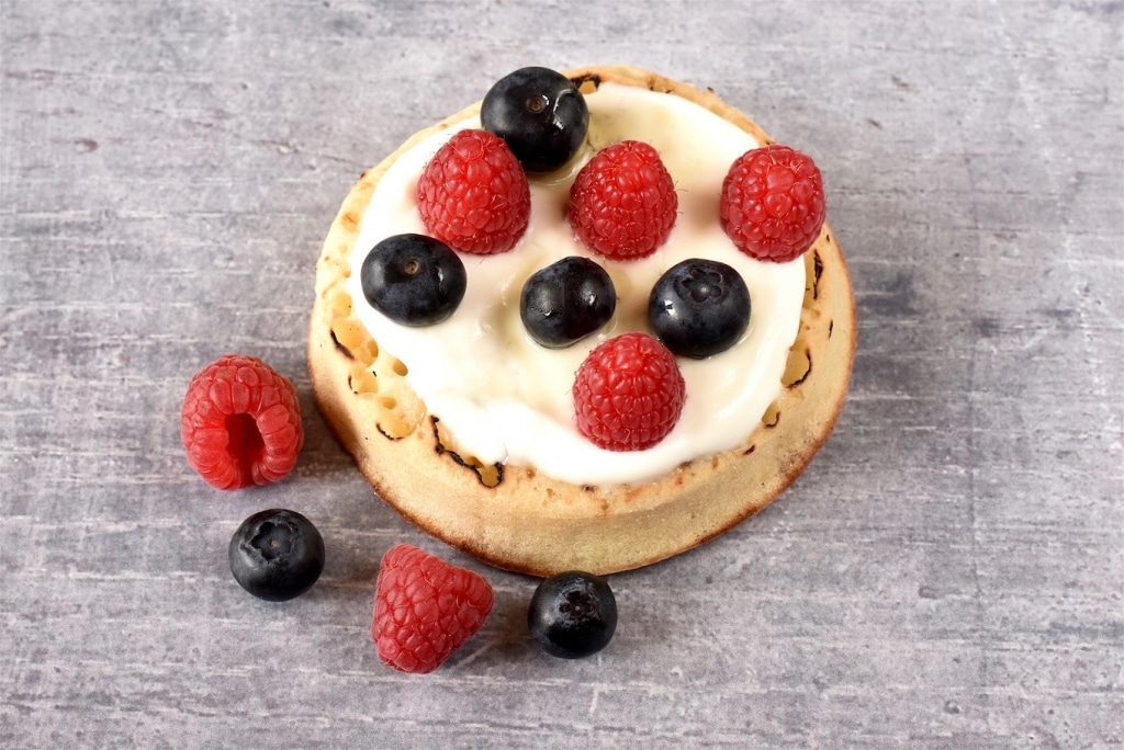 A Crumpet topped with greek yoghurt, blueberries and raspberries