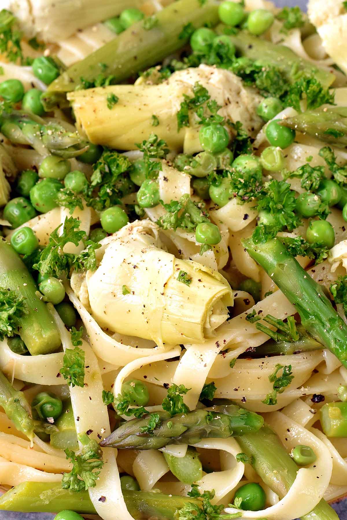 Artichokes, peas and asparagus mixed in with pasta and topped with herbs.