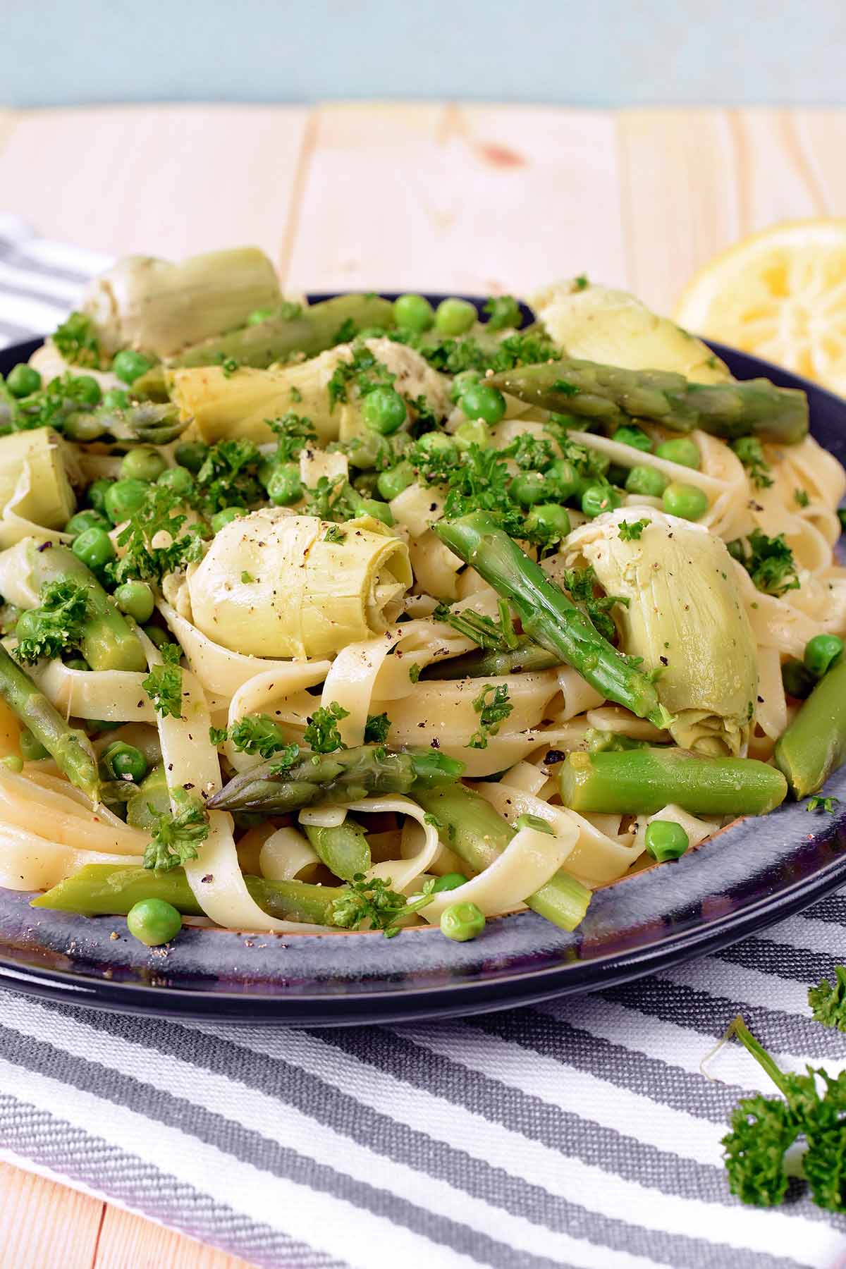 A plate of vegetable pasta on a wooden surface.