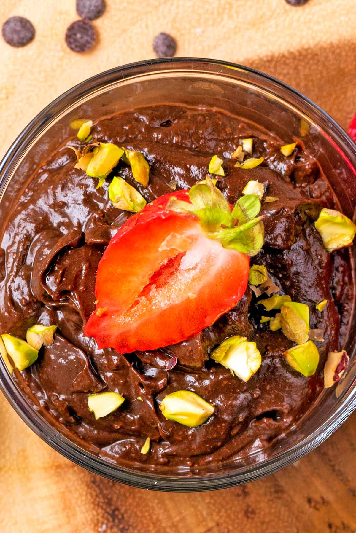 Chocolate pudding topped with chopped nuts and a strawberry half.