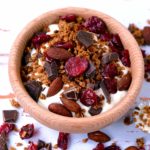 Chocolate and cranberry granola in a small wooden bowl.