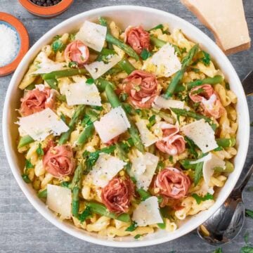 Asparagus and prosciutto pasta in a large round bowl.