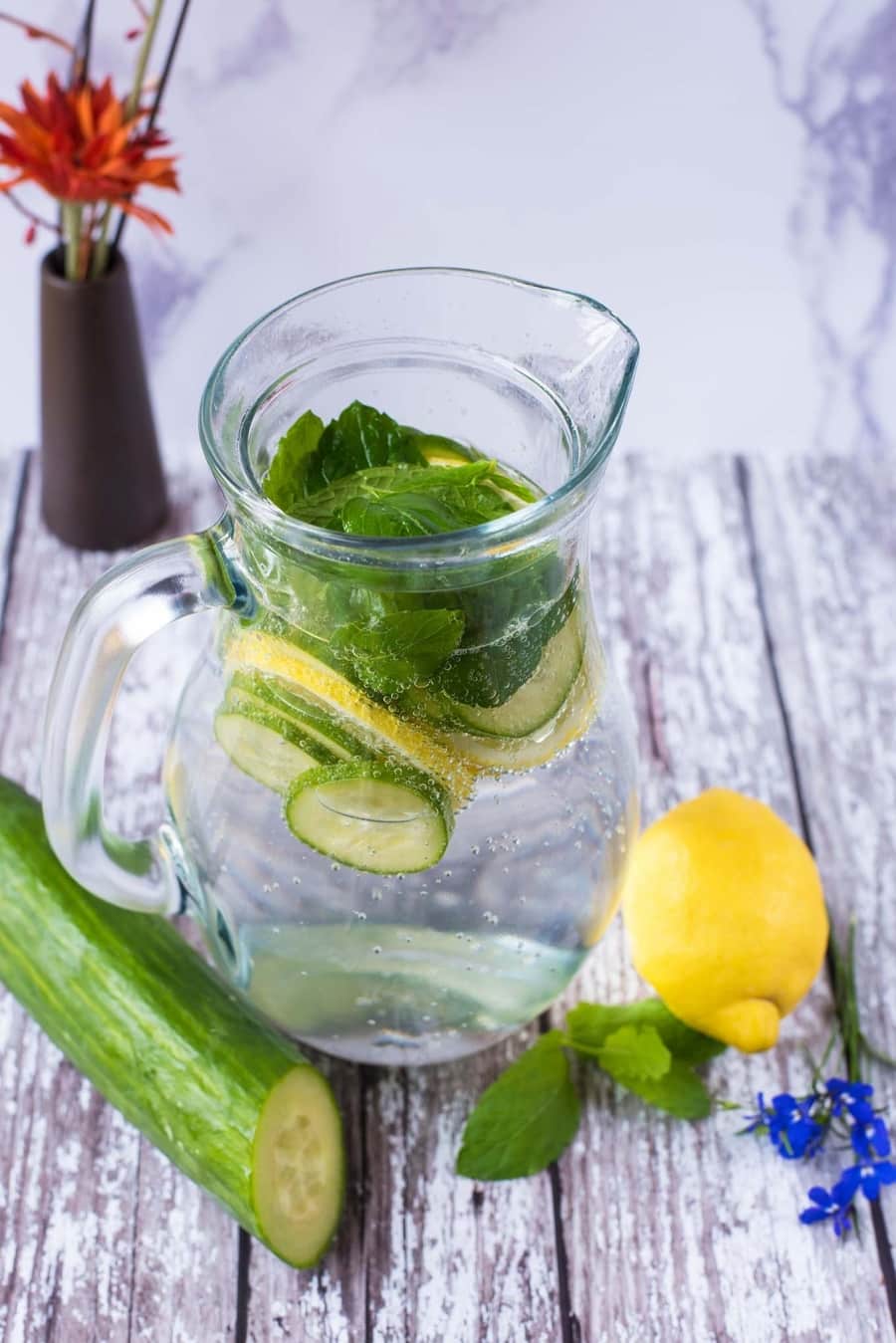 A jug of water containing mint, lemon and cucumber.