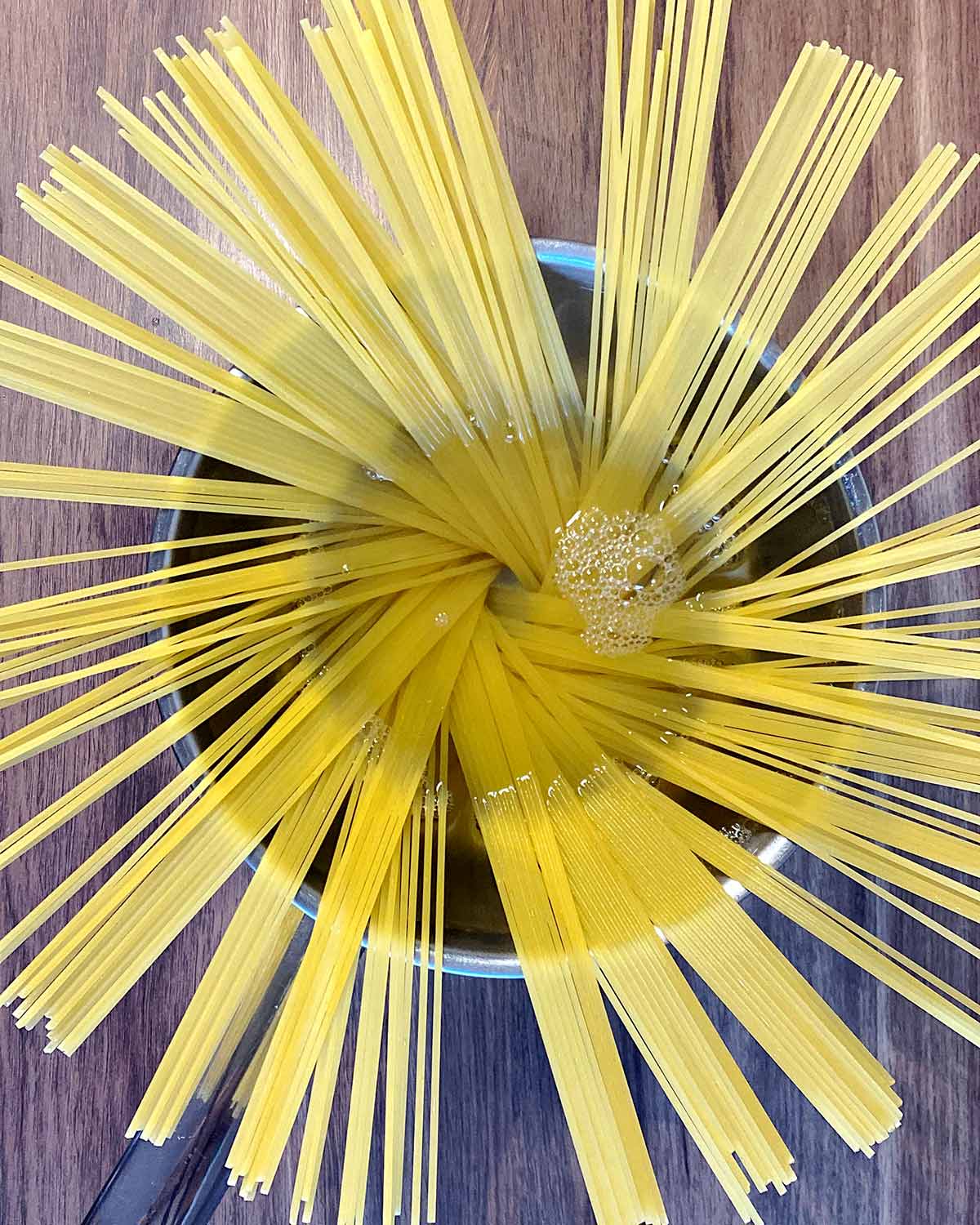 Spaghetti in a pan of water.