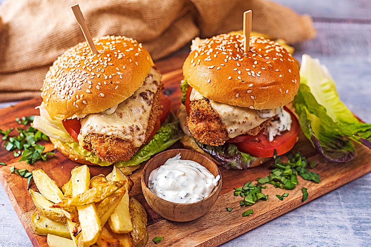 Two chicken burgers on a serving board