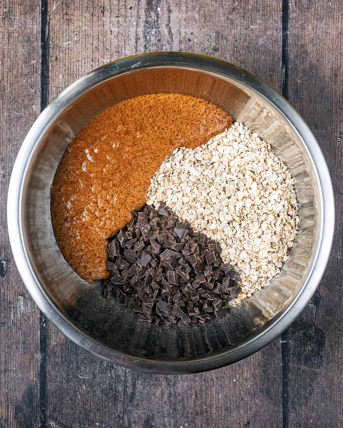 The peanut butter mixture in a bowl with oats and chocolate chips.