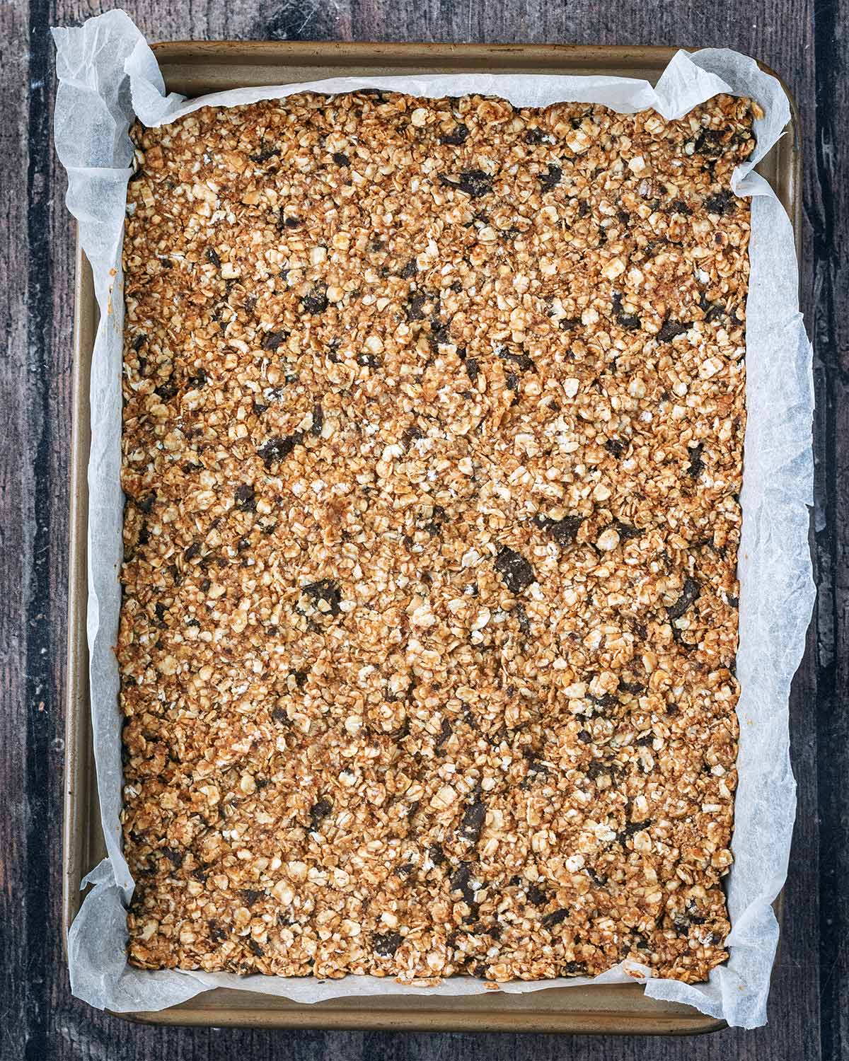 The oat mixture packed down into a lined baking tray.