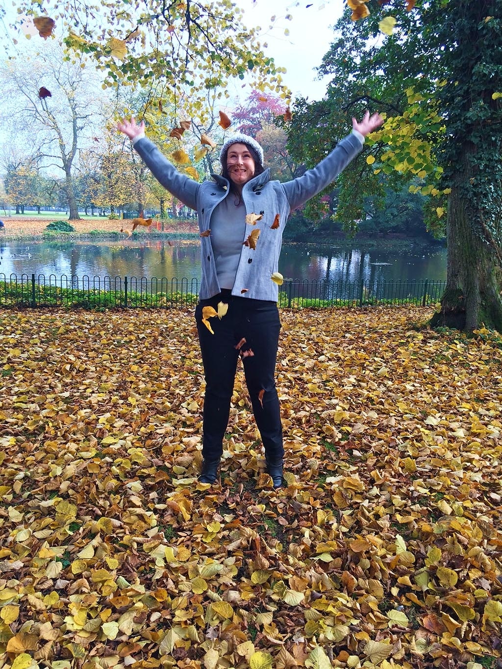 Dannii stood in a load of fallen leaves throwing some leaves in the air