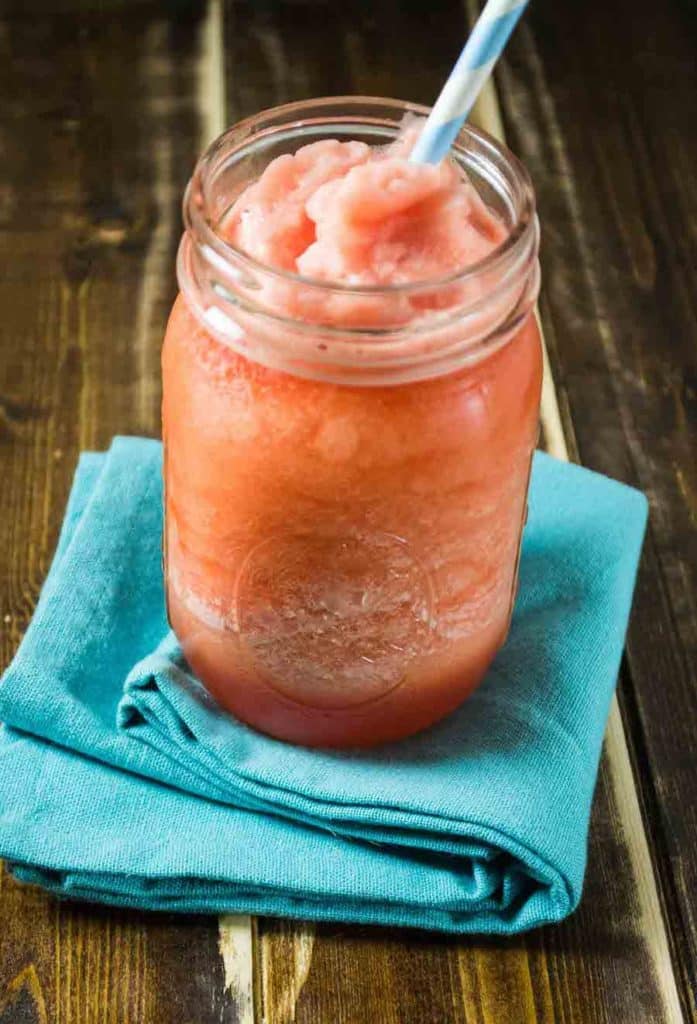 An orange coloured slushy drink in a mason jar