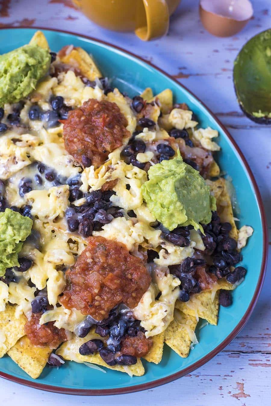 Nachos covered in black beans, salsa, guacamole and melted cheese.