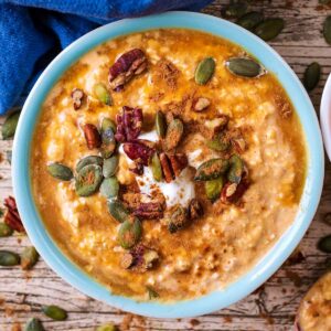 A bowl of pumpkin overnight oats topped with seeds and nuts