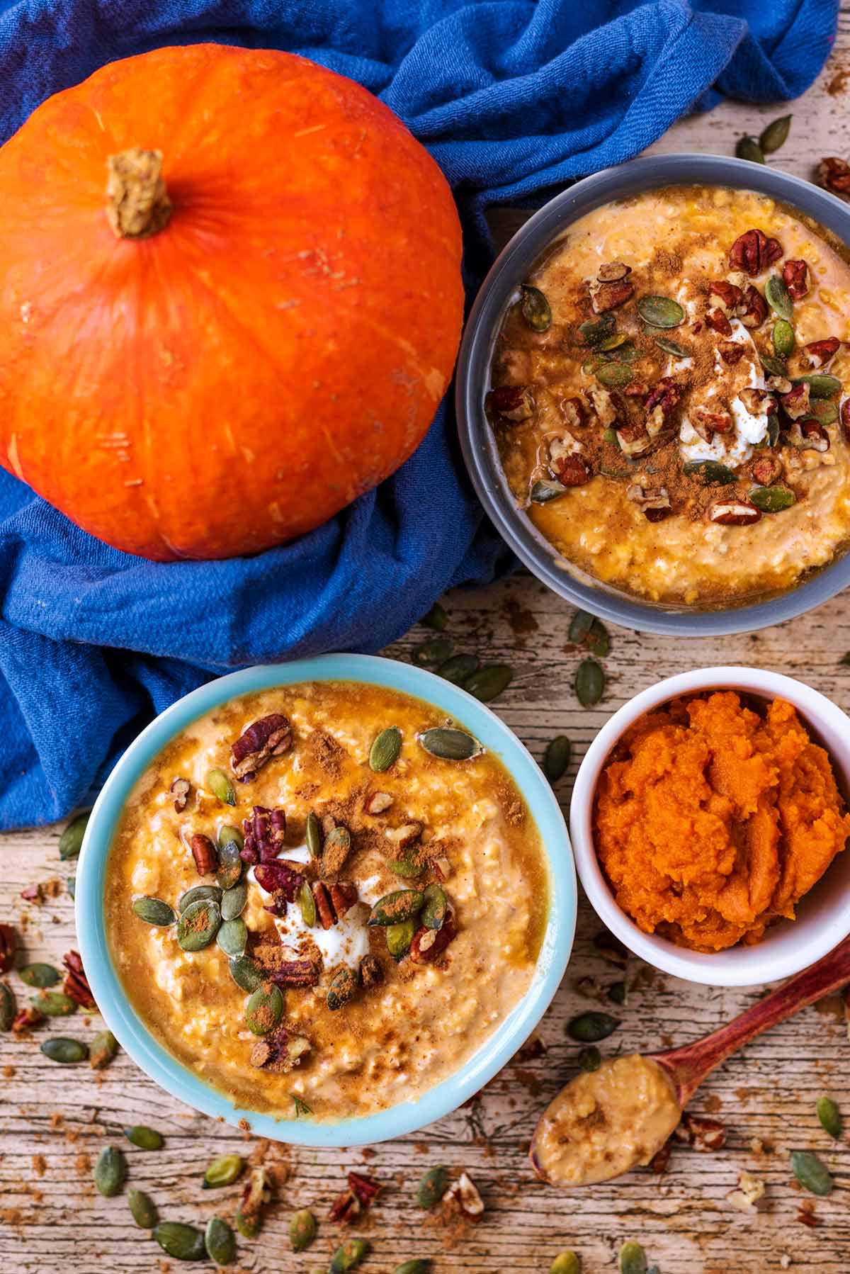 Two bowls of overnight oats next to a whole pumpkin.