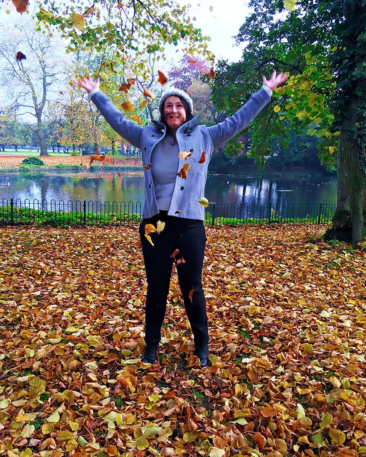 Dannii stood in a load of fallen leaves throwing some leaves in the air