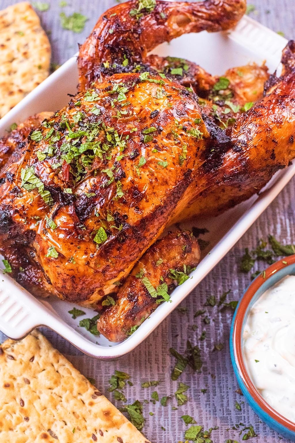 Harissa Roasted Chicken covered in chopped herbs.