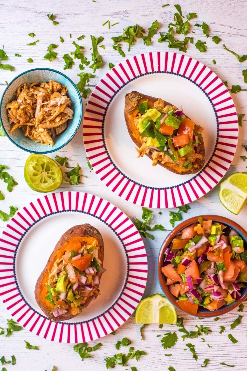 Two BBQ Chicken Stuffed Sweet Potatoes on red and white plates.