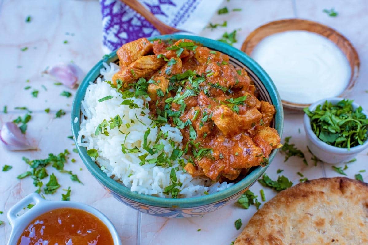 Curry, rice, naan bread, chutney and yogurt.